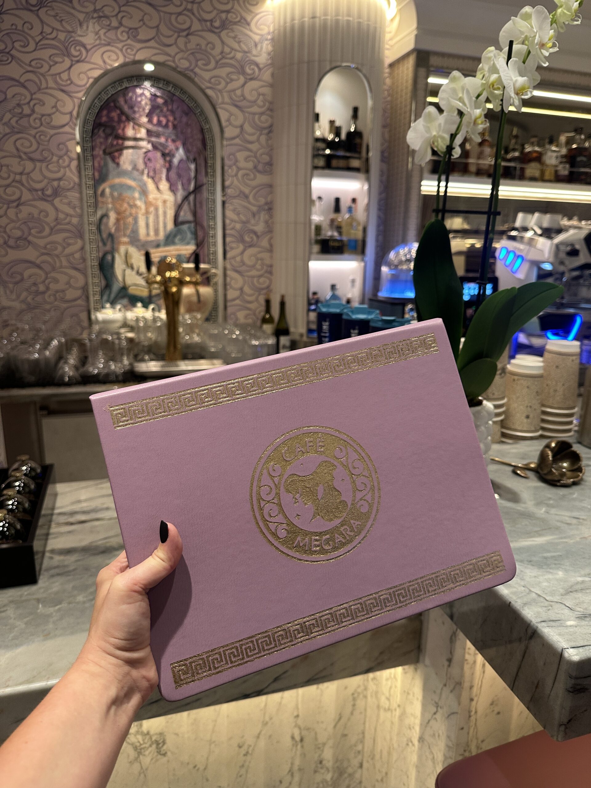 Get a first look at Café Megara on the Disney Destiny, a cozy Hercules-themed café offering coffee, cocktails, and Disney magic.