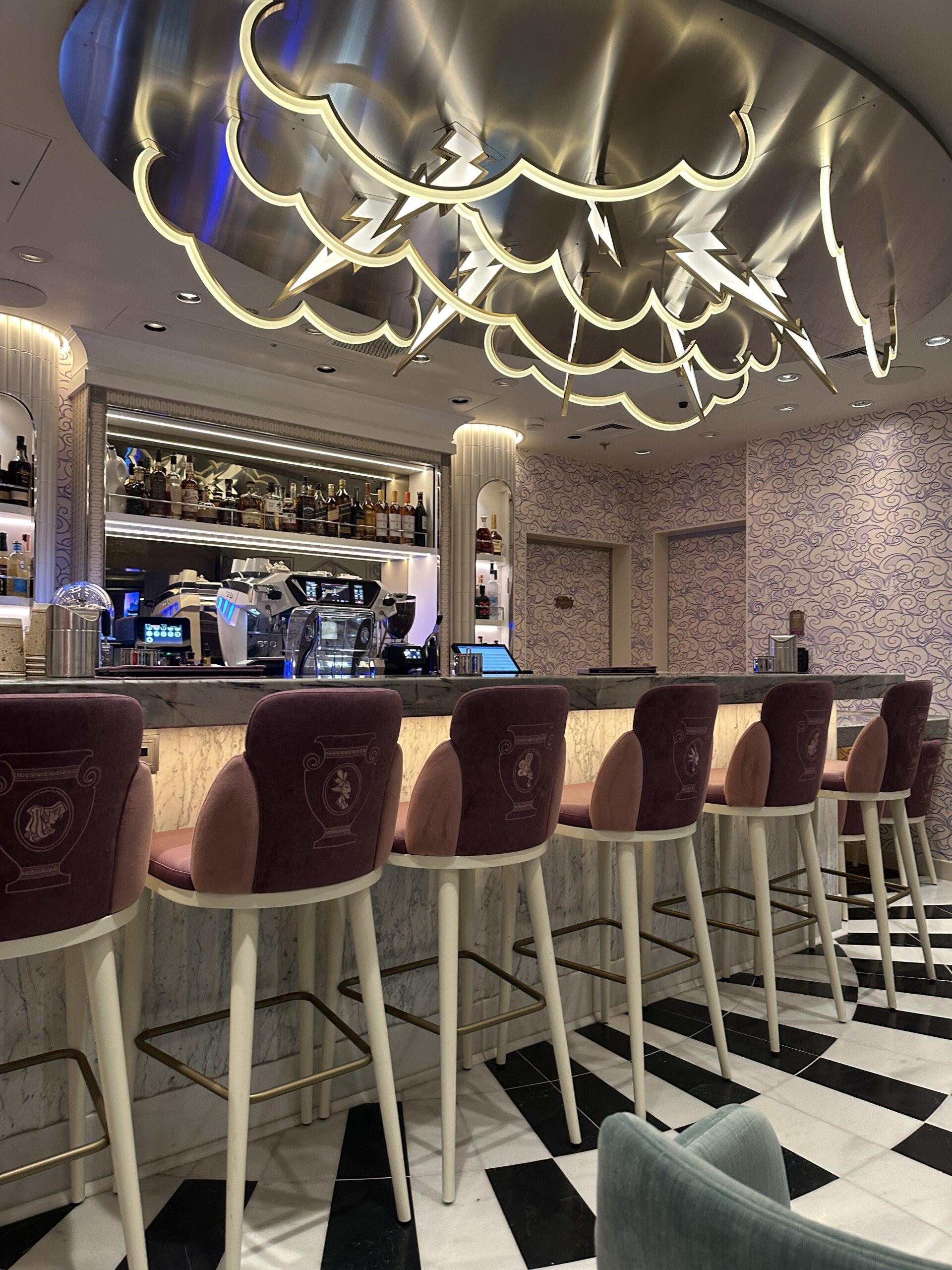 Get a first look at Café Megara on the Disney Destiny, a cozy Hercules-themed café offering coffee, cocktails, and Disney magic.